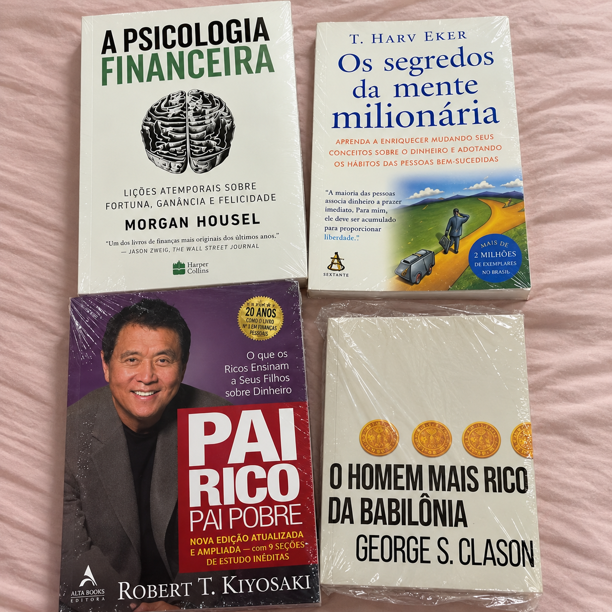 Os quatro livros de educação financeira embalados sobre tecido rosa