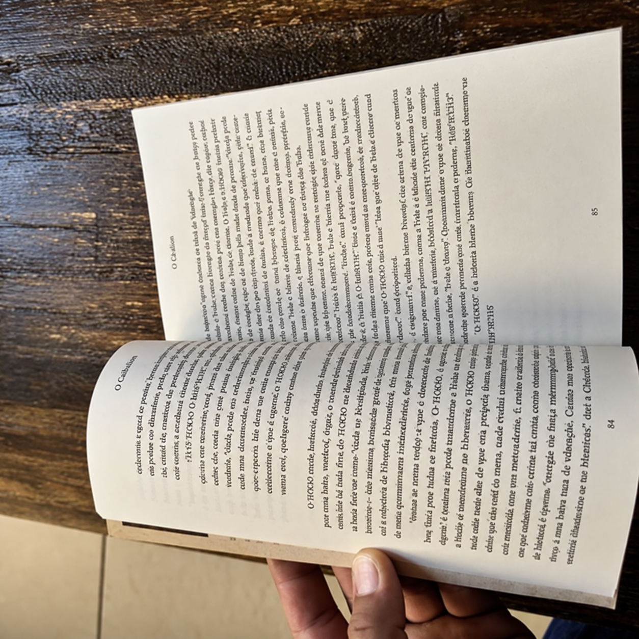 Livro O Caibalion aberto sobre uma mesa de madeira